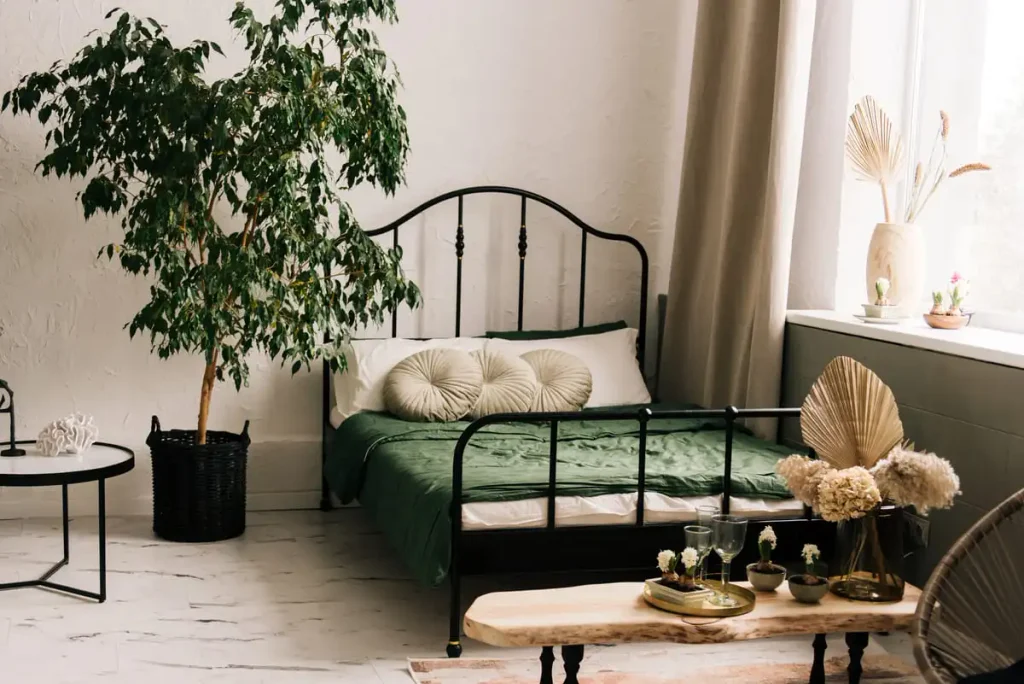 wrought-iron bed styled with vases of flowers and layered textiles