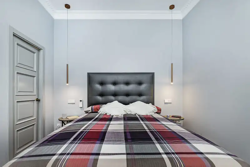 Bright fabric headboard above a colorful patchwork bedspread
