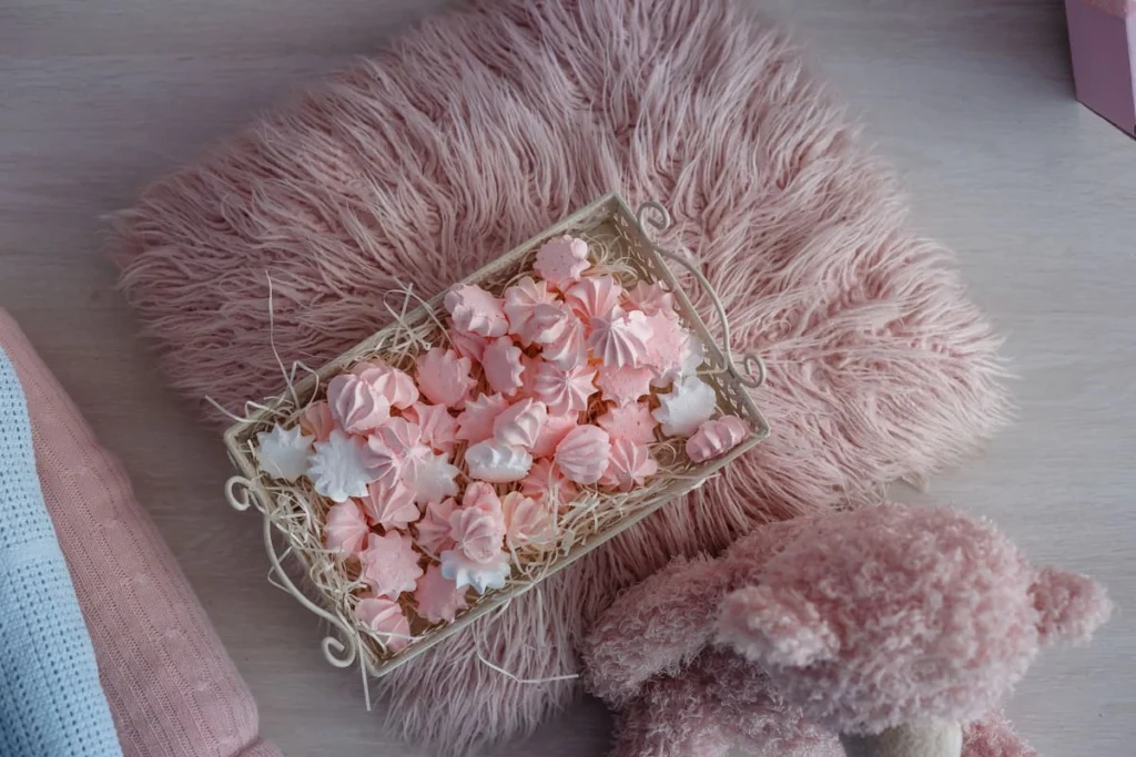 Coquette room decor in a bright white bedroom with pink throws and fresh flowers