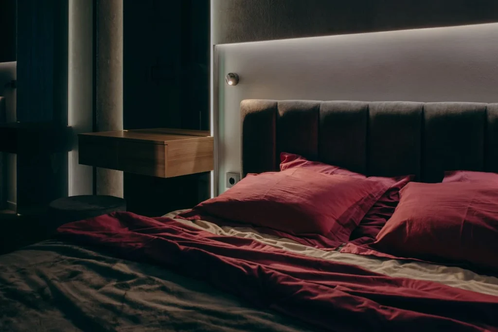 Dark coquette bedroom with deep red bedding on the bed
