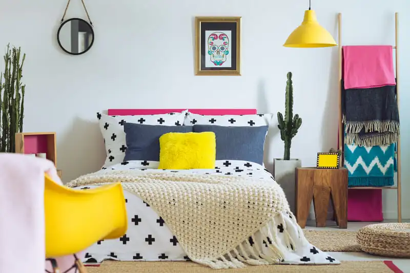 Bedroom mixing several bold colors in the bedding, furniture and decor