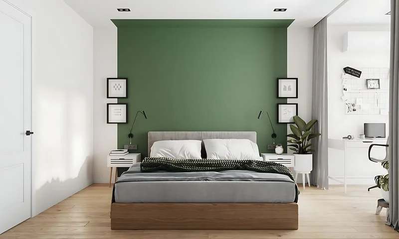 Goblincore bedroom with a deep green accent wall, wooden furniture, and warm lighting.
