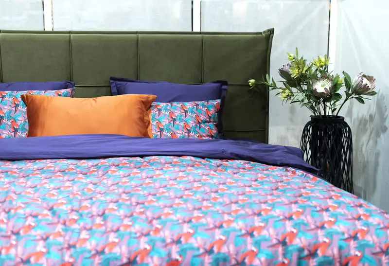 Soft bed layered with multicolored pillows