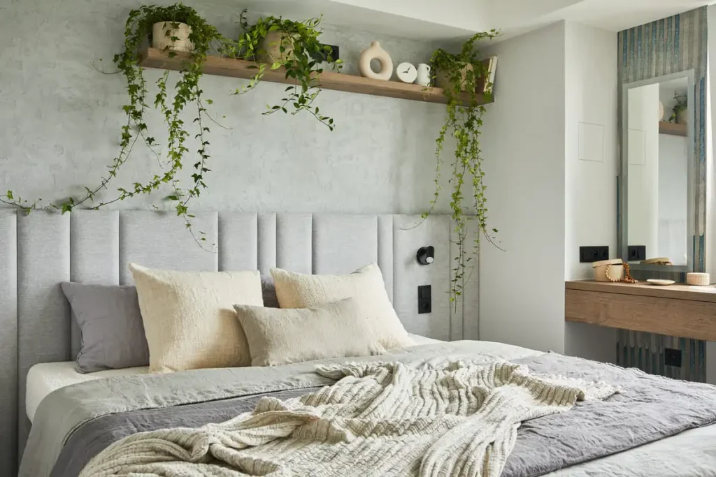 mall sunny bedroom with a compact bed, white bedding, a wooden storage chest and potted plants