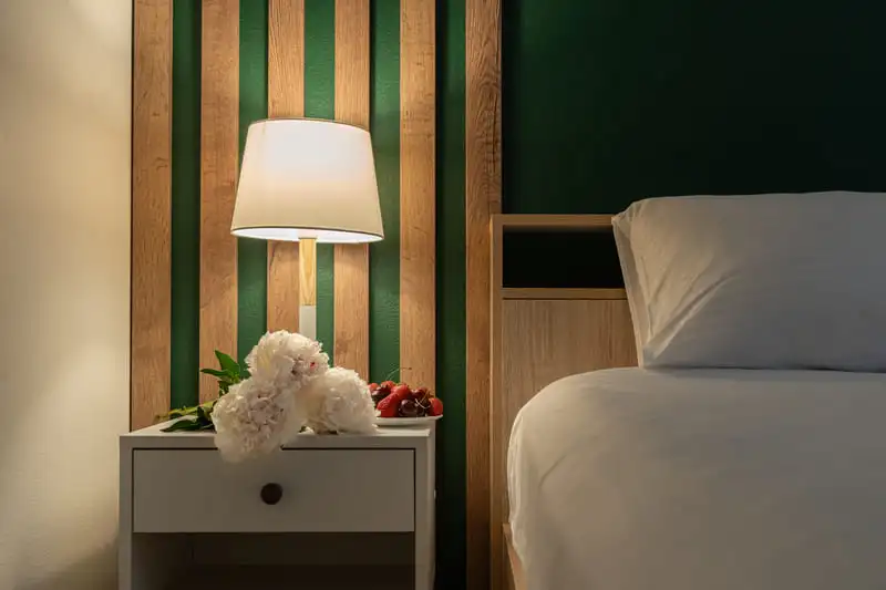 Dopamine decor bedroom with a bedside lamp casting warm light in a green and white bedroom.